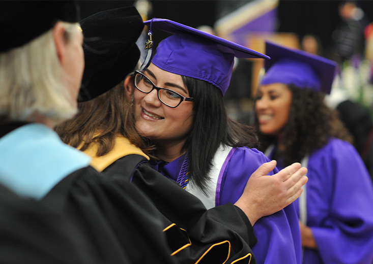 Student hugging professor at graduation