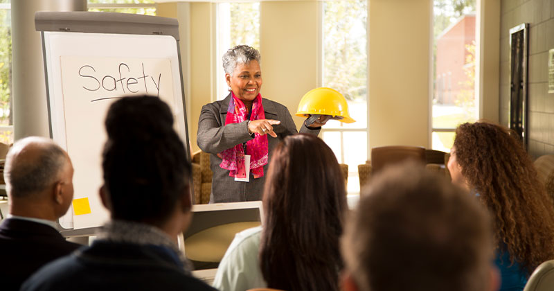 Professor at white board teaching about safety to organizational leadership students